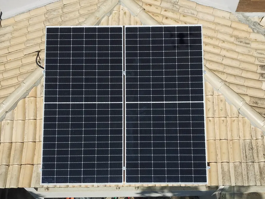 Dois módulos solares recém-instalados em telhado cerâmico