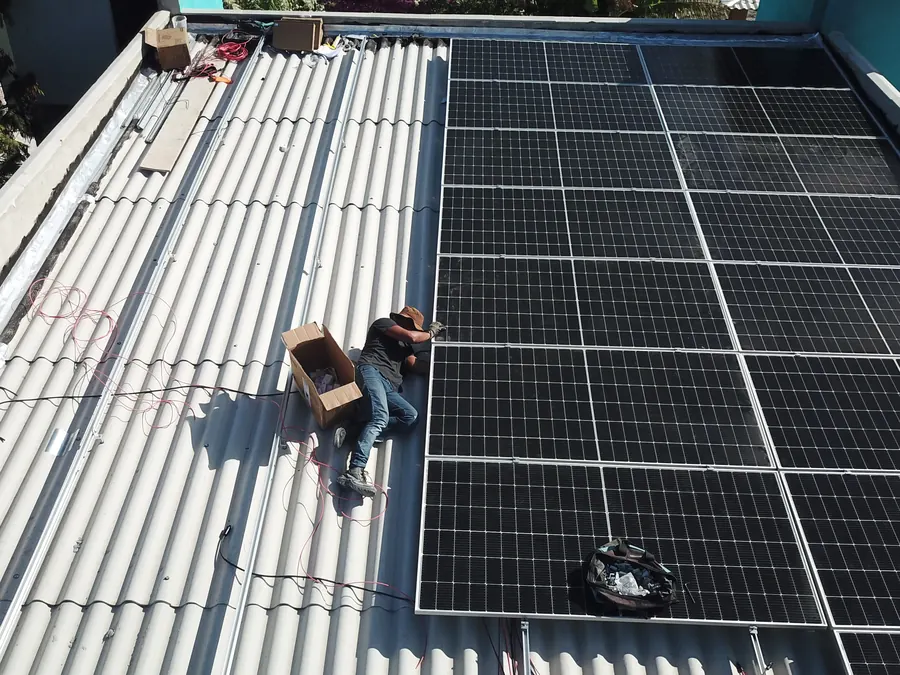 Equipe da Meta Rio fixando os módulos solares no telhado